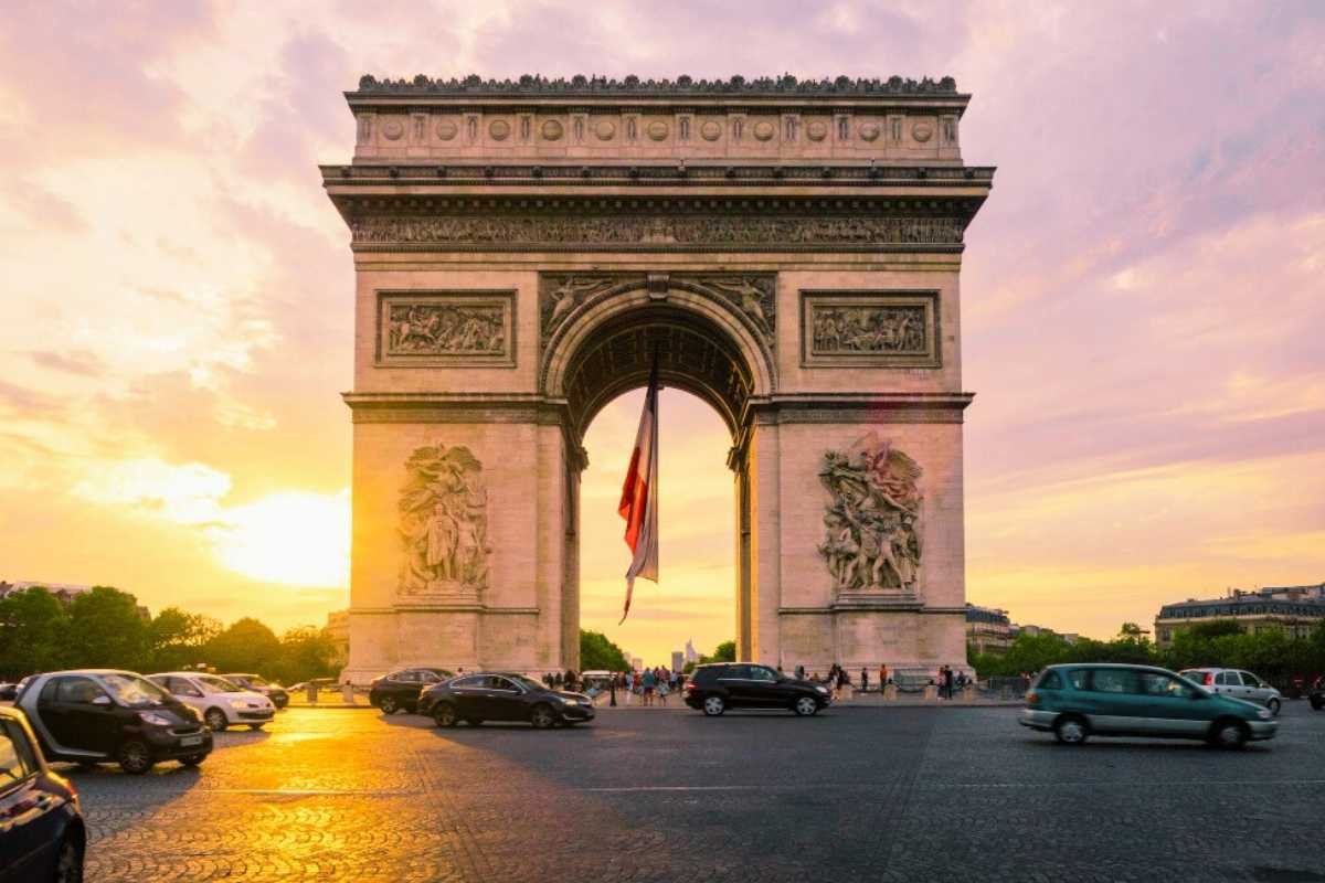 Arc de Triomphe at sunset with traffic and city lights