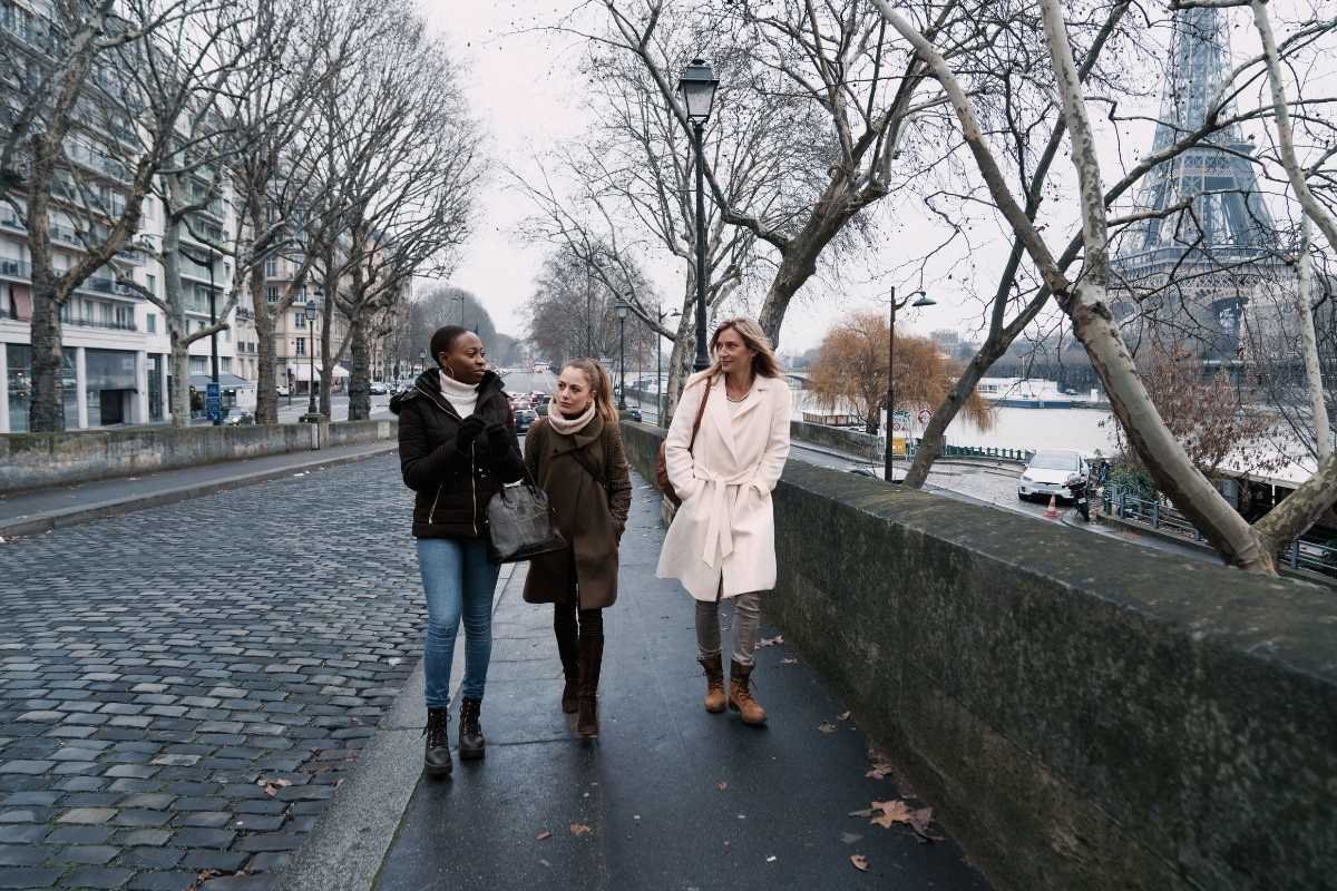 Paris winter itinerary 2026: grey daylight near the Seine with bundled-up travelers, showing short days and why anchors and warm breaks matter
