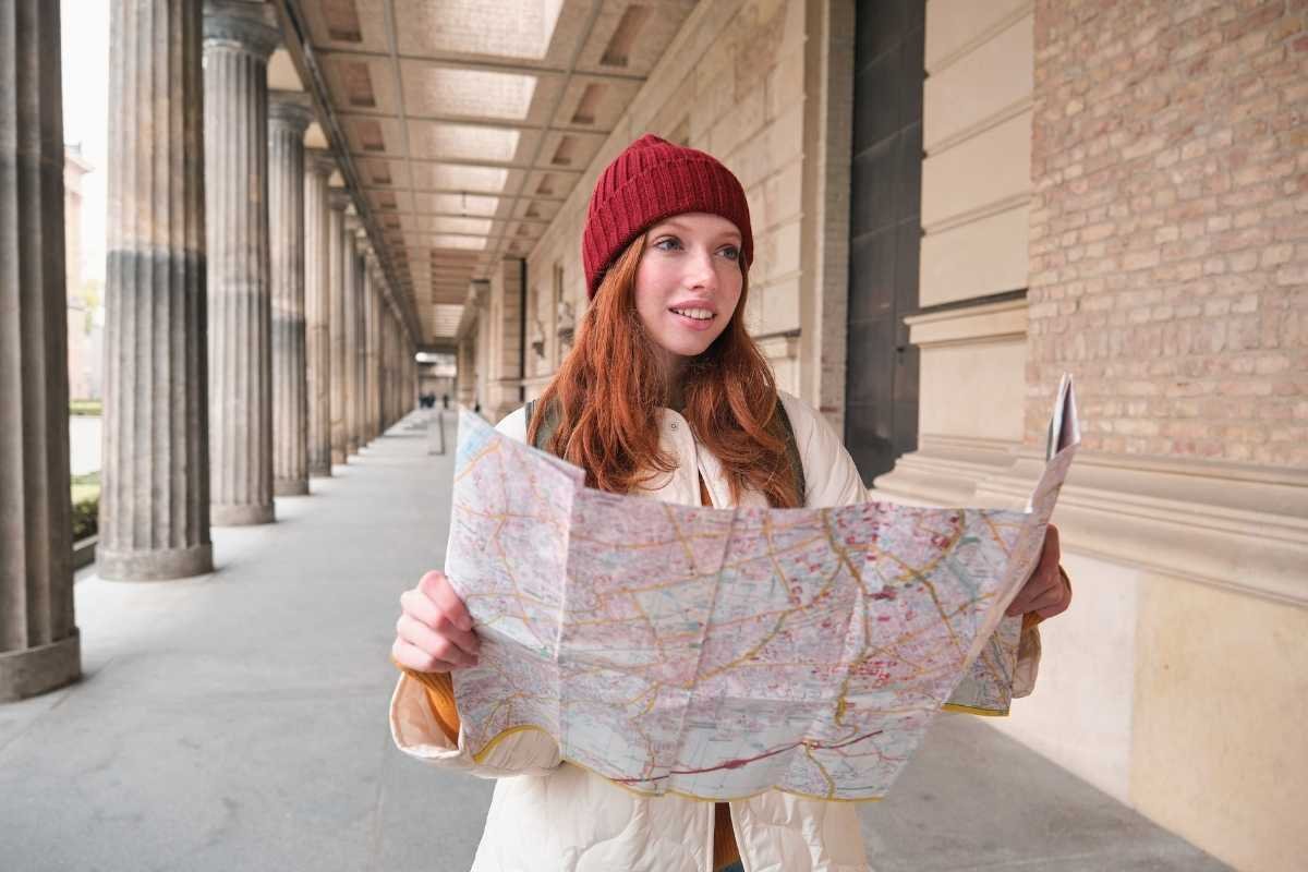 Traveler checking a map in Paris during winter, planning a route on a cold and quiet street.
