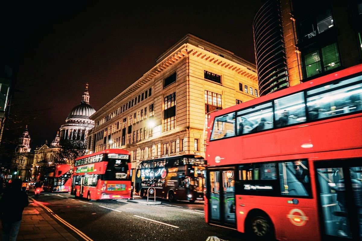 London Safety Guide 2026: evening street near a transport hub with strong lighting and visible foot traffic, showing why clear returns reduce night risk