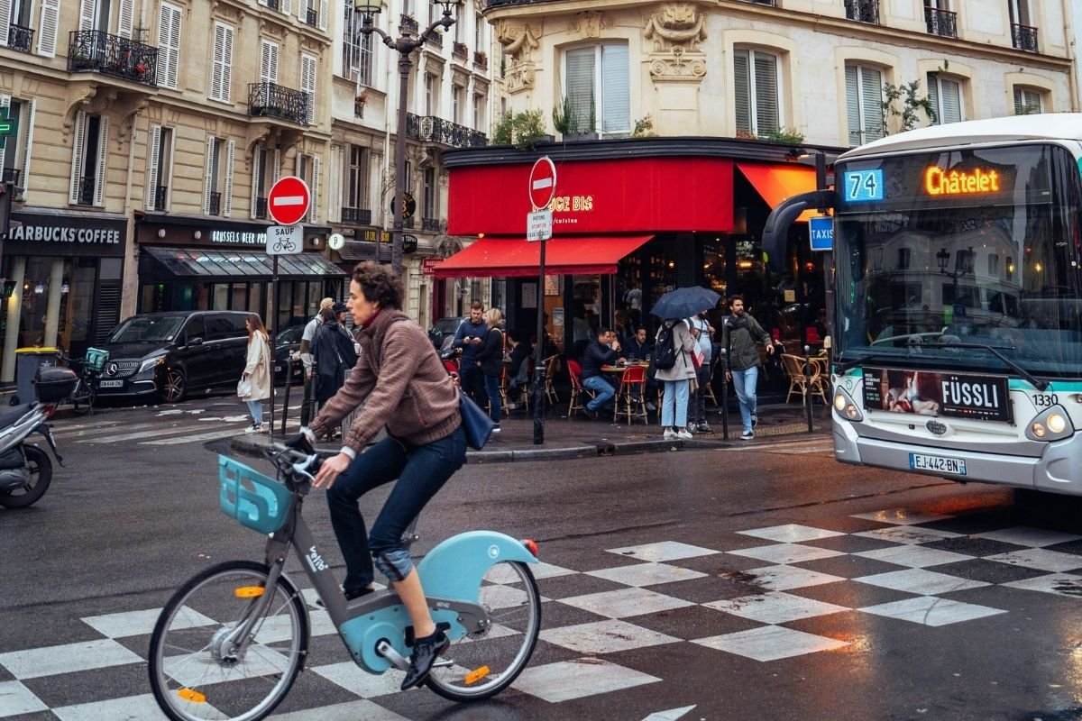 Is Paris expensive for tourists in 2026: busy Paris street with cafés and transport, showing how repeated convenience spending raises daily costs