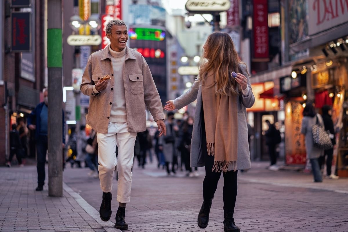 couple walking past illuminated Paris streets in the evening, illustrating how atmosphere-driven choices affect spending
