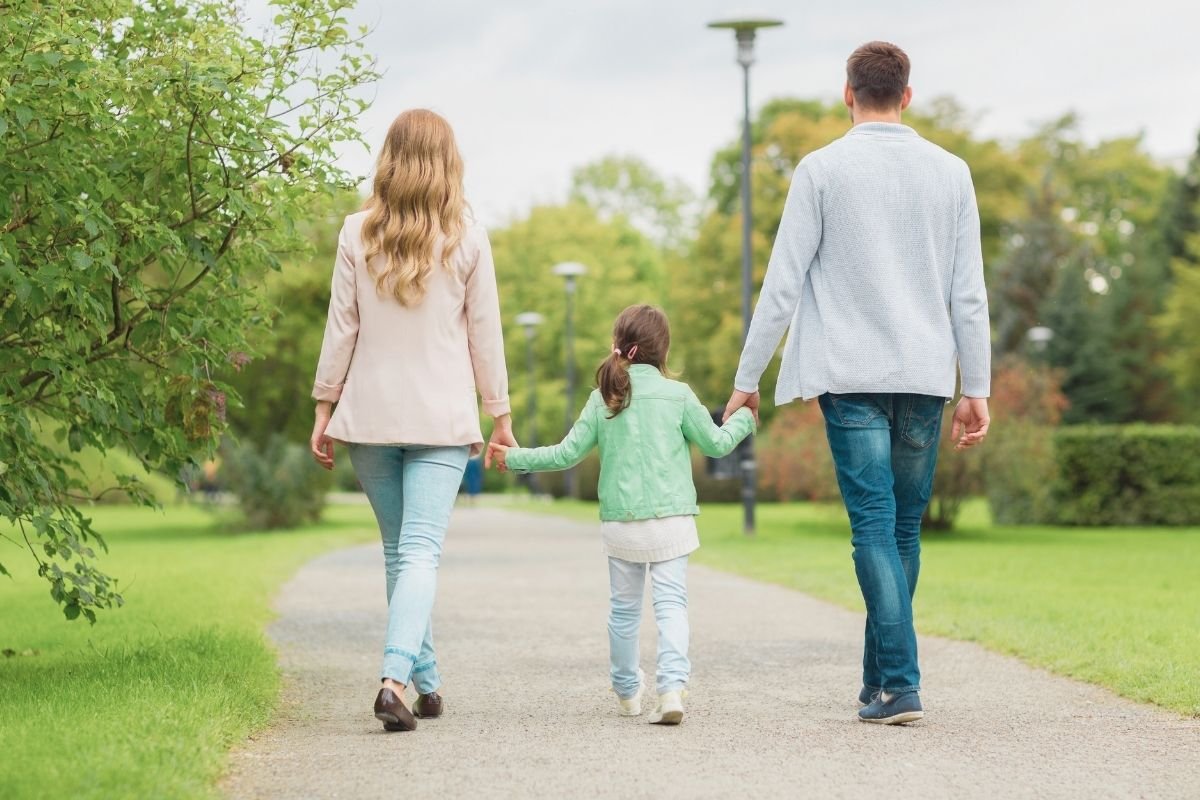 family walking calmly near a Paris park in daylight, showing how a stable base and slower rhythm makes trips feel longer