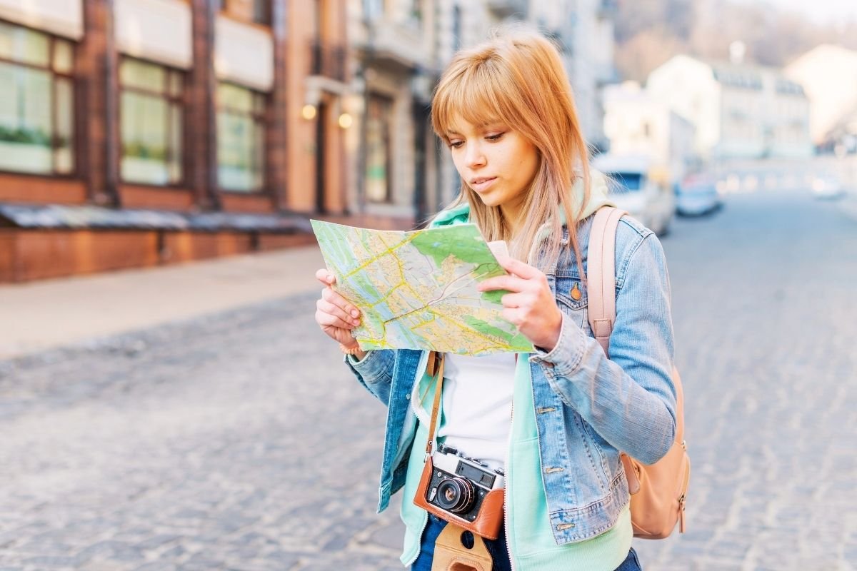 Paris tourist traps that look innocent: first-time visitors checking maps at a busy Paris intersection, showing how small navigation friction can quietly waste hours