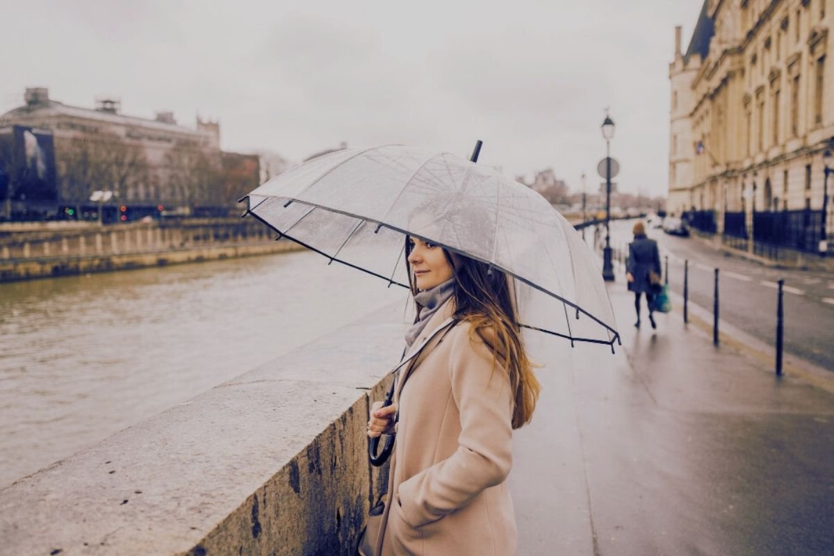 Is Paris worth visiting in winter: rainy Paris street with umbrellas, showing rain creates friction and changes pacing