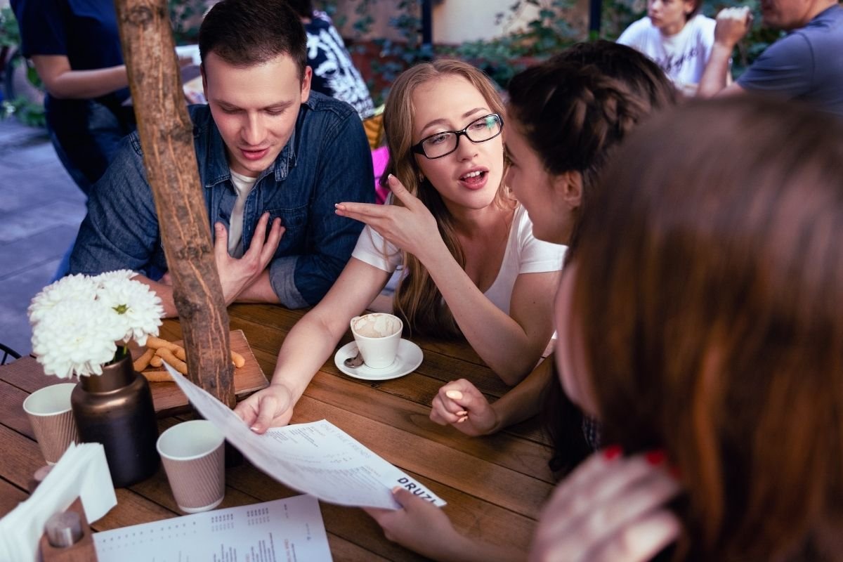 tourists reviewing expenses at an outdoor café, showing how daily spending depends on travel style