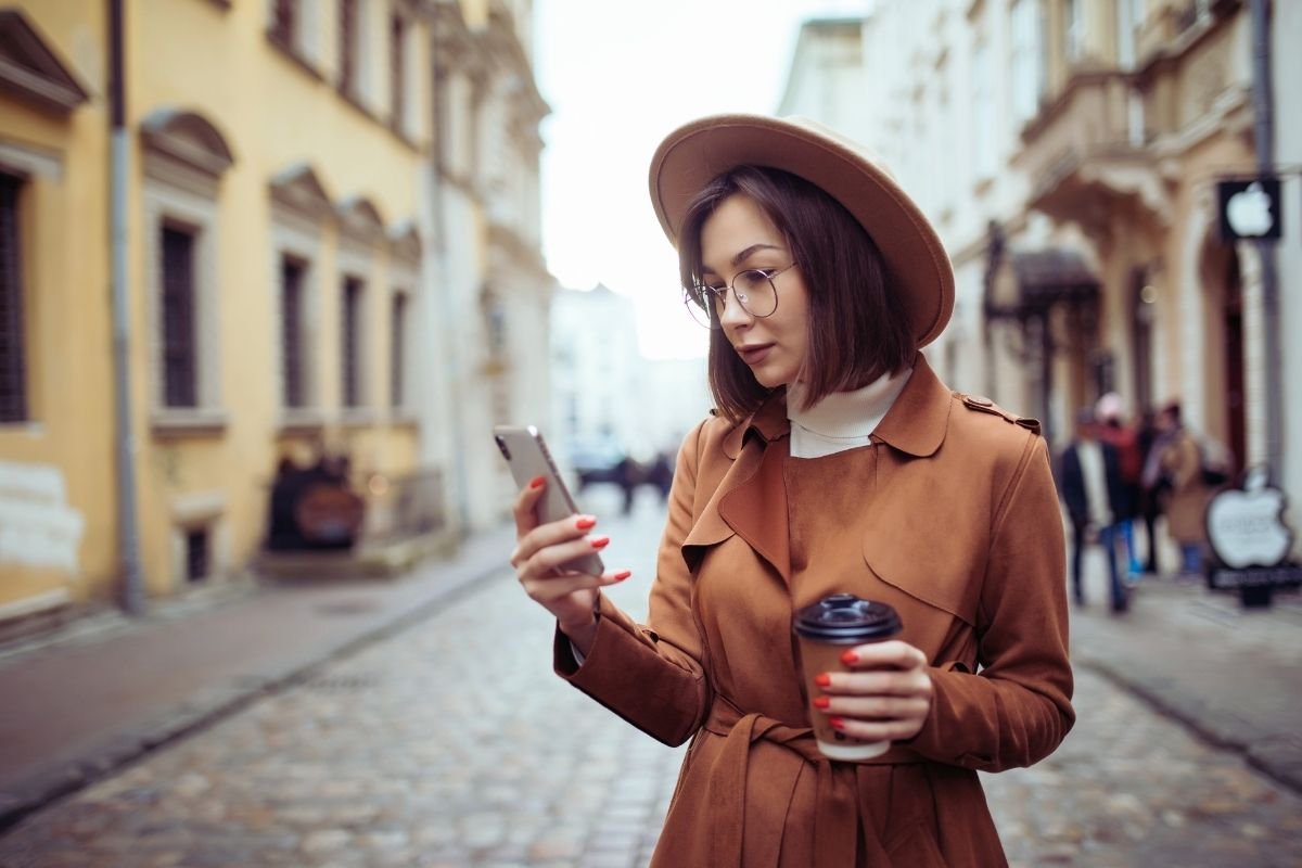 traveler checking a phone map while walking in a Paris neighborhood, showing how a stable day plan prevents wasted time and wrong turns