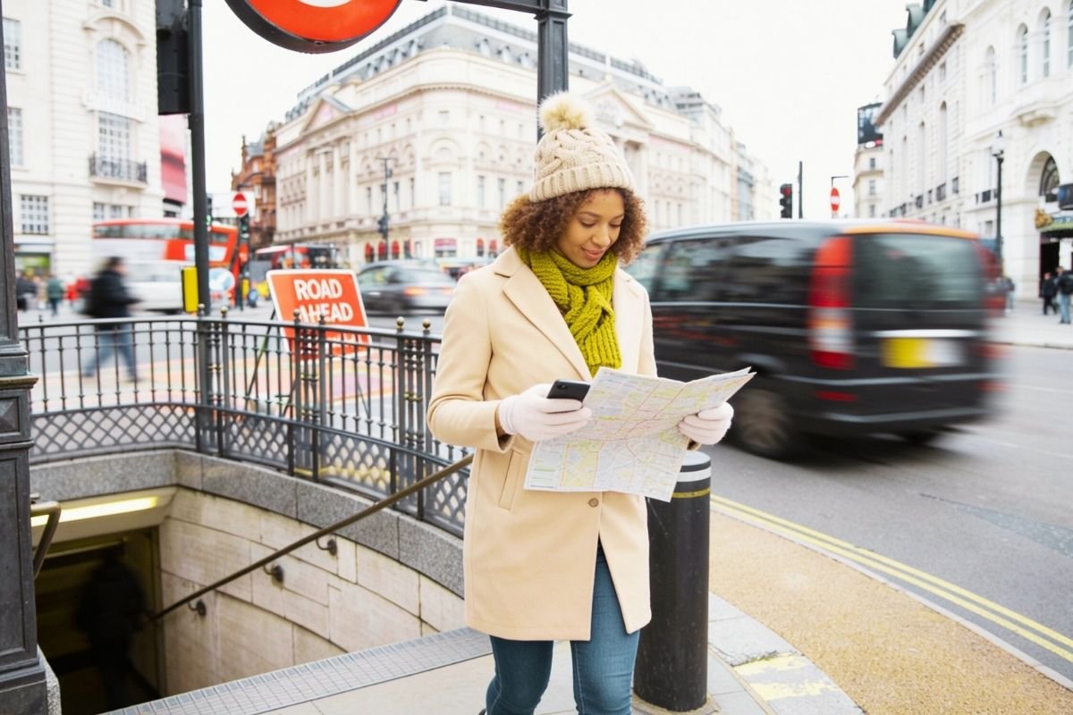 How to get around London (2026): traveler exiting a station checking directions as the city moves fast