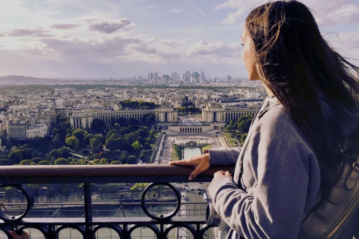 traveler in winter coat looking over Paris viewpoint, showing calm winter rhythm
