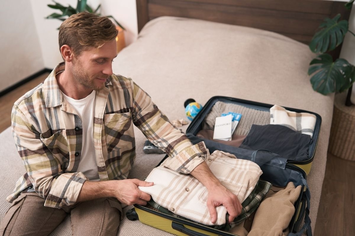 Paris packing list (2026) for winter: traveler packing a carry-on with layering pieces