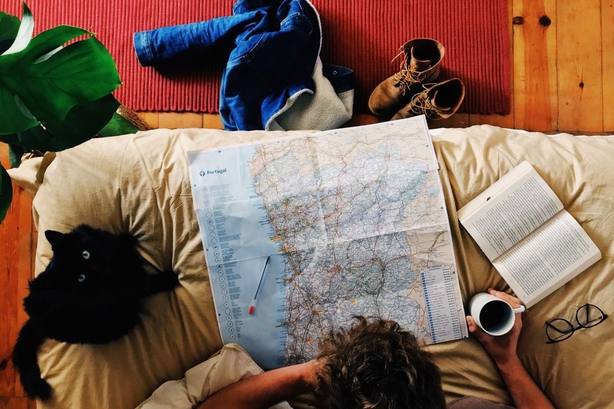 Best Paris tickets to book in advance 2026: traveler resting indoors with a phone and map, showing how planned resets and clean returns prevent burnout