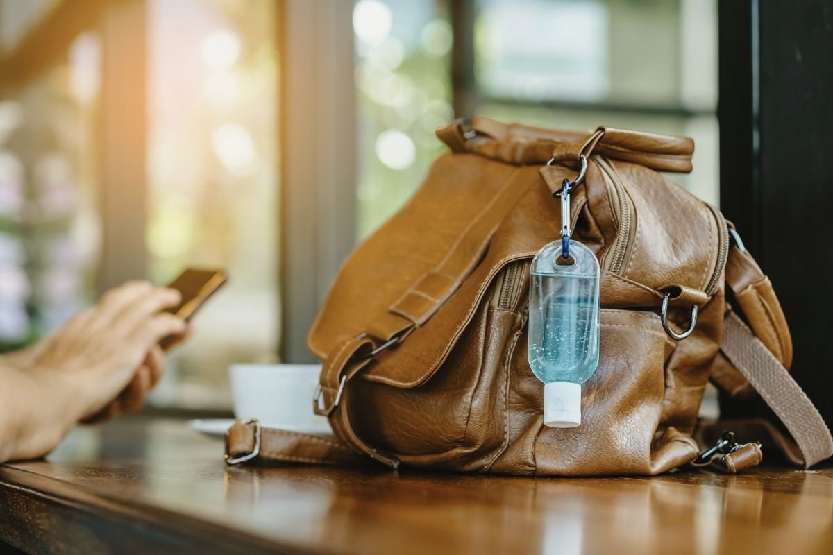 traveler using a small day pouch with gloves, tissues, power bank and lip balm during a winter walk, preventing small problems from breaking the day