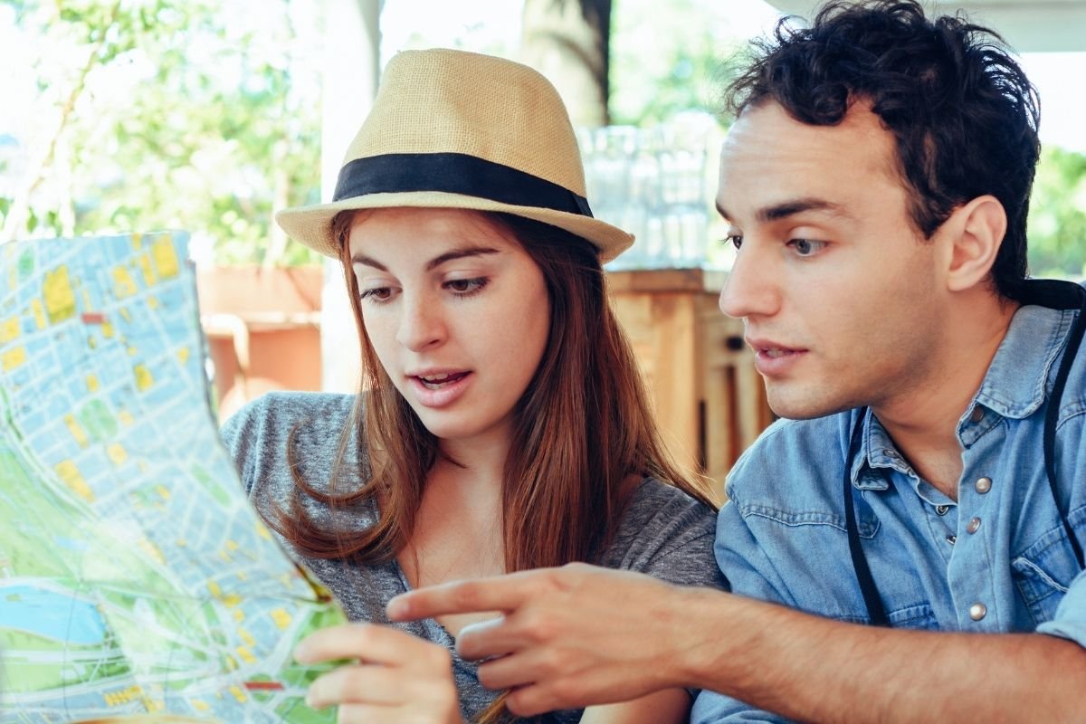 How many days in Paris is enough: travelers studying a Paris map at a café table, illustrating the tension between limited time and too many options