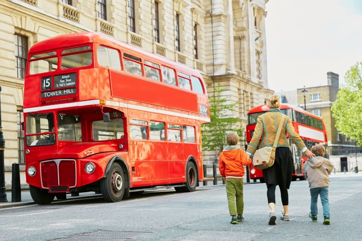 London red bus with a parent and stroller—buses reduce stairs and keep family movement simpler.
