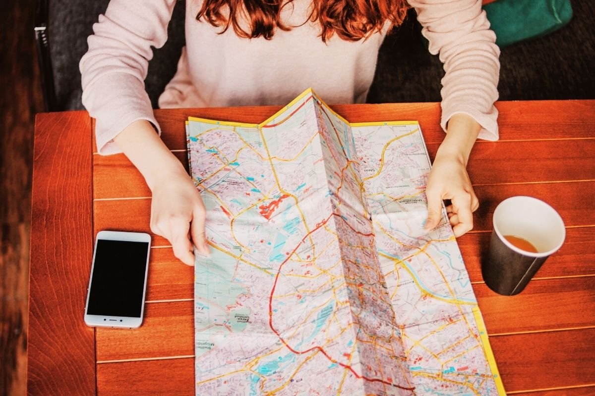 Budget traveler planning a London stay on a map—choosing pockets and micro-locations reduces friction and overspending.