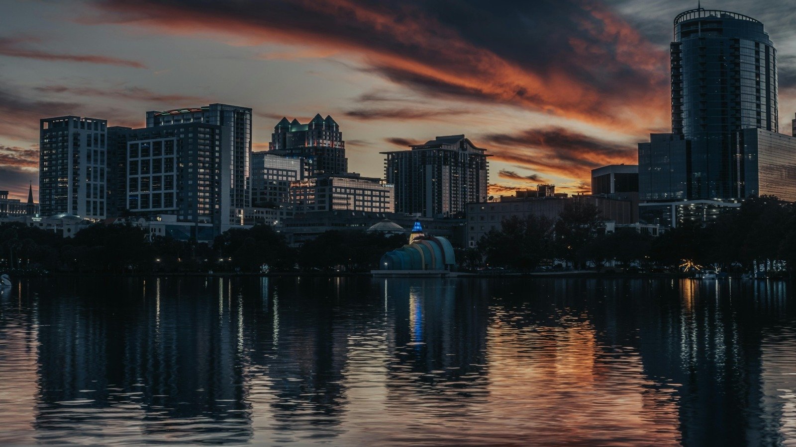 Downtown Orlando skyline at dusk with lake reflections and city lights