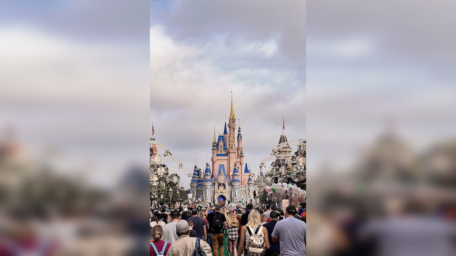Visitors walking through a crowded Orlando theme park during a busy vacation day