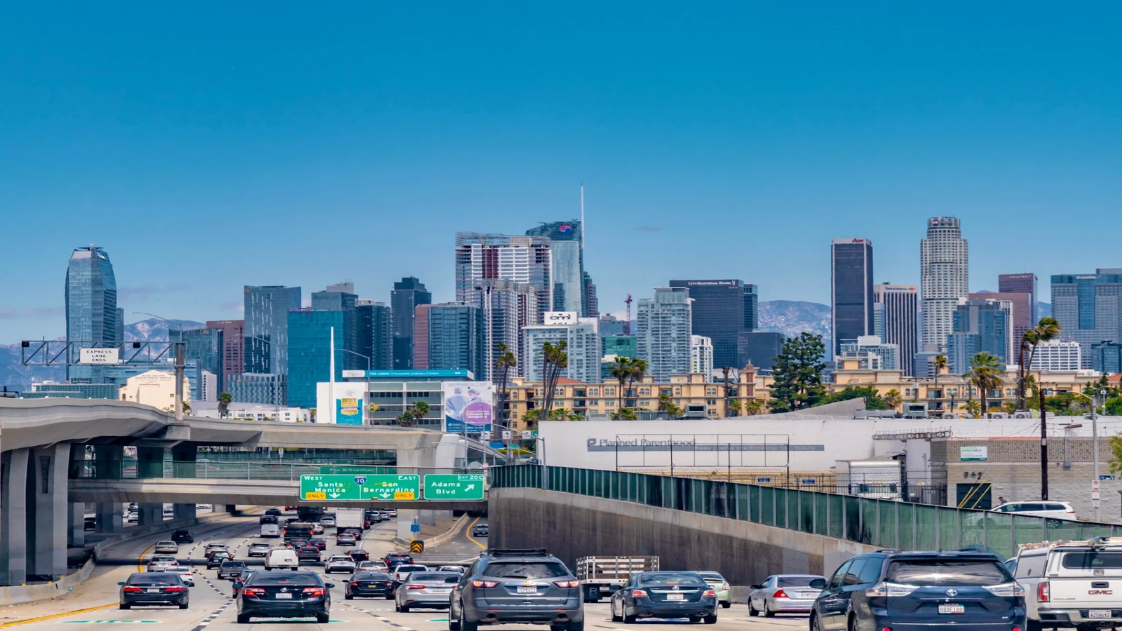 Heavy traffic approaching downtown Los Angeles on a sunny afternoon.