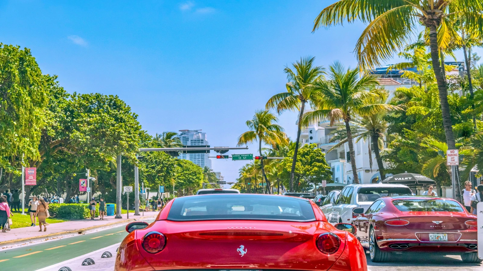 Palm-lined Ocean Drive in Miami with summer traffic and visitors.
