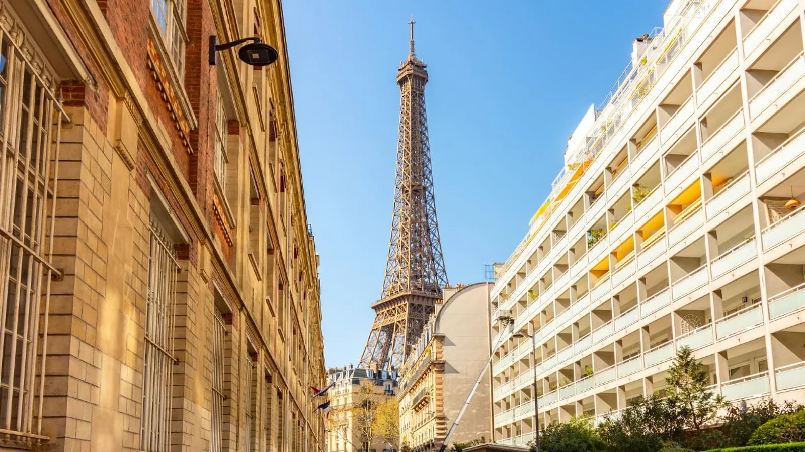 Street view of the Eiffel Tower framed by buildings in Paris