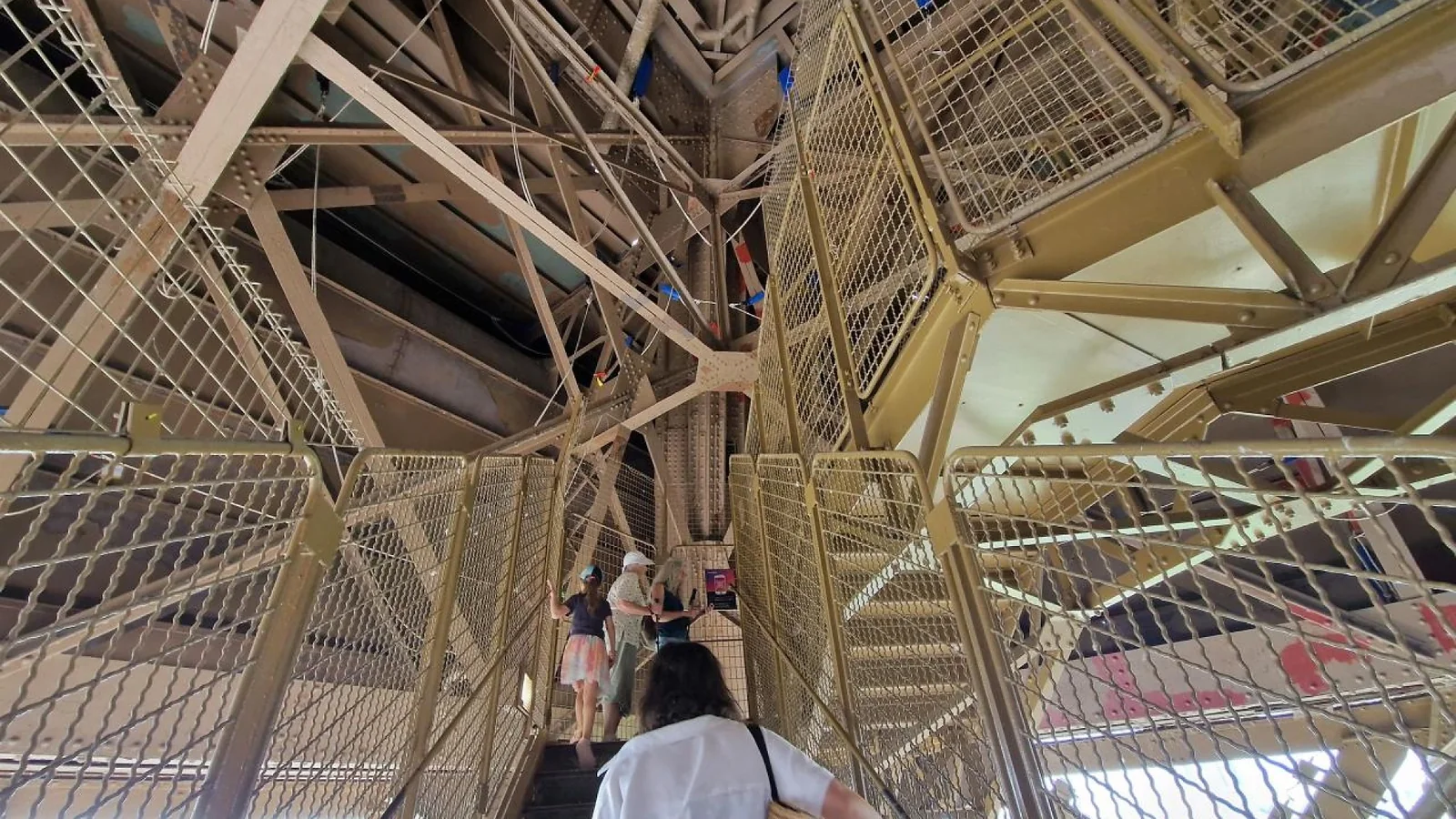 Visitors climbing stairs through the landmark’s iron framework