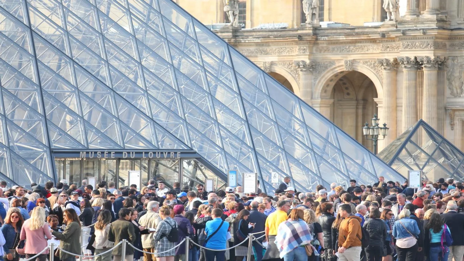 Visitors waiting near the Pyramid entrance before entering.
