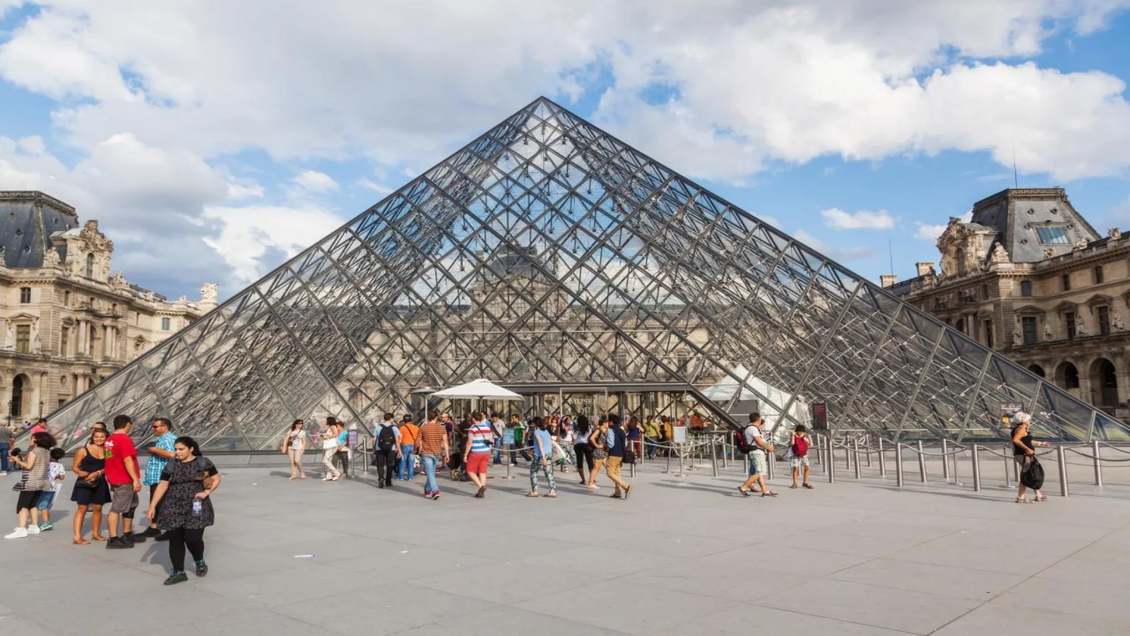 Visitors entering the Louvre Museum through the Pyramid Entrance in Paris.