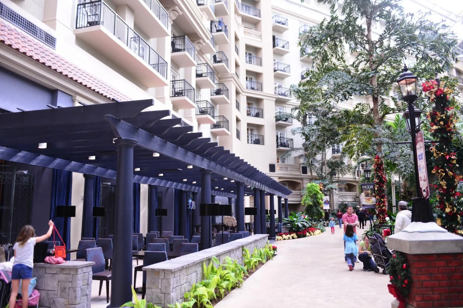 Orlando hotel with outdoor seating, balconies, and families walking through the resort.