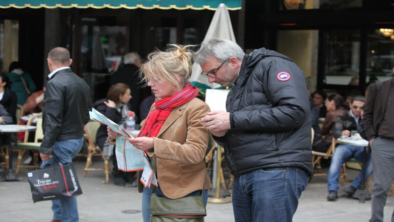 Tourists checking a map near Paris restaurants while deciding where to eat
