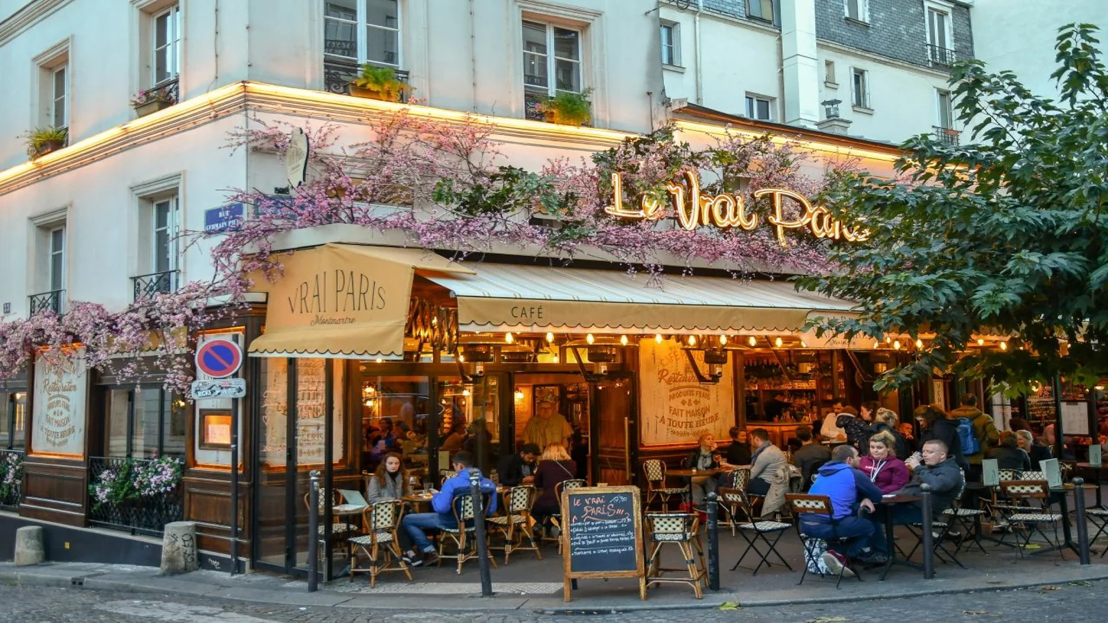 Busy café terrace on a quiet Paris street during lunchtime