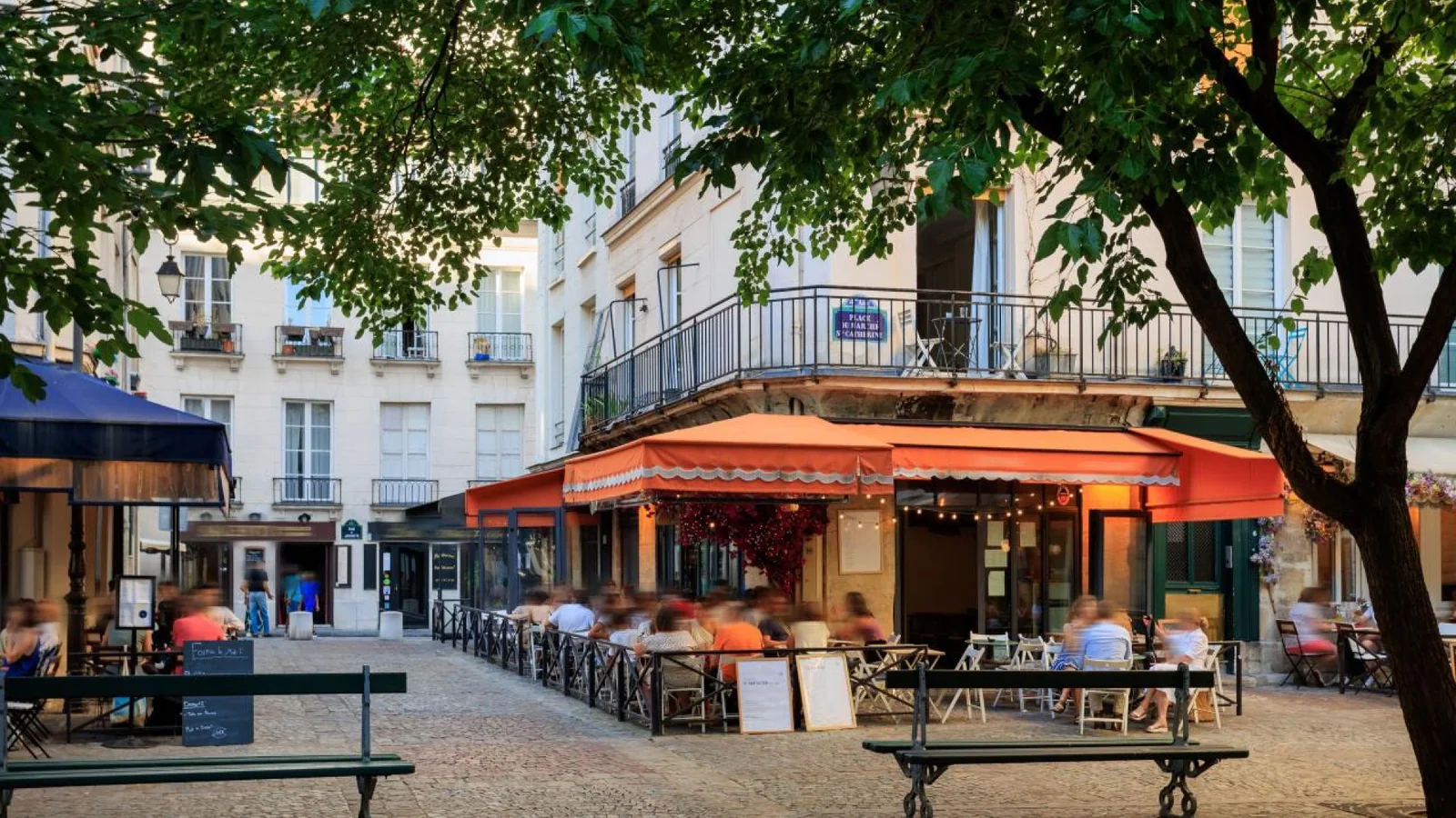 Paris café terrace with menu boards in a busy square