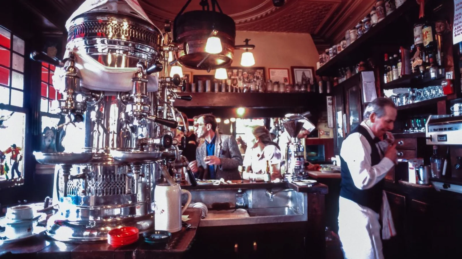 Barista working beside an espresso machine in a Paris café