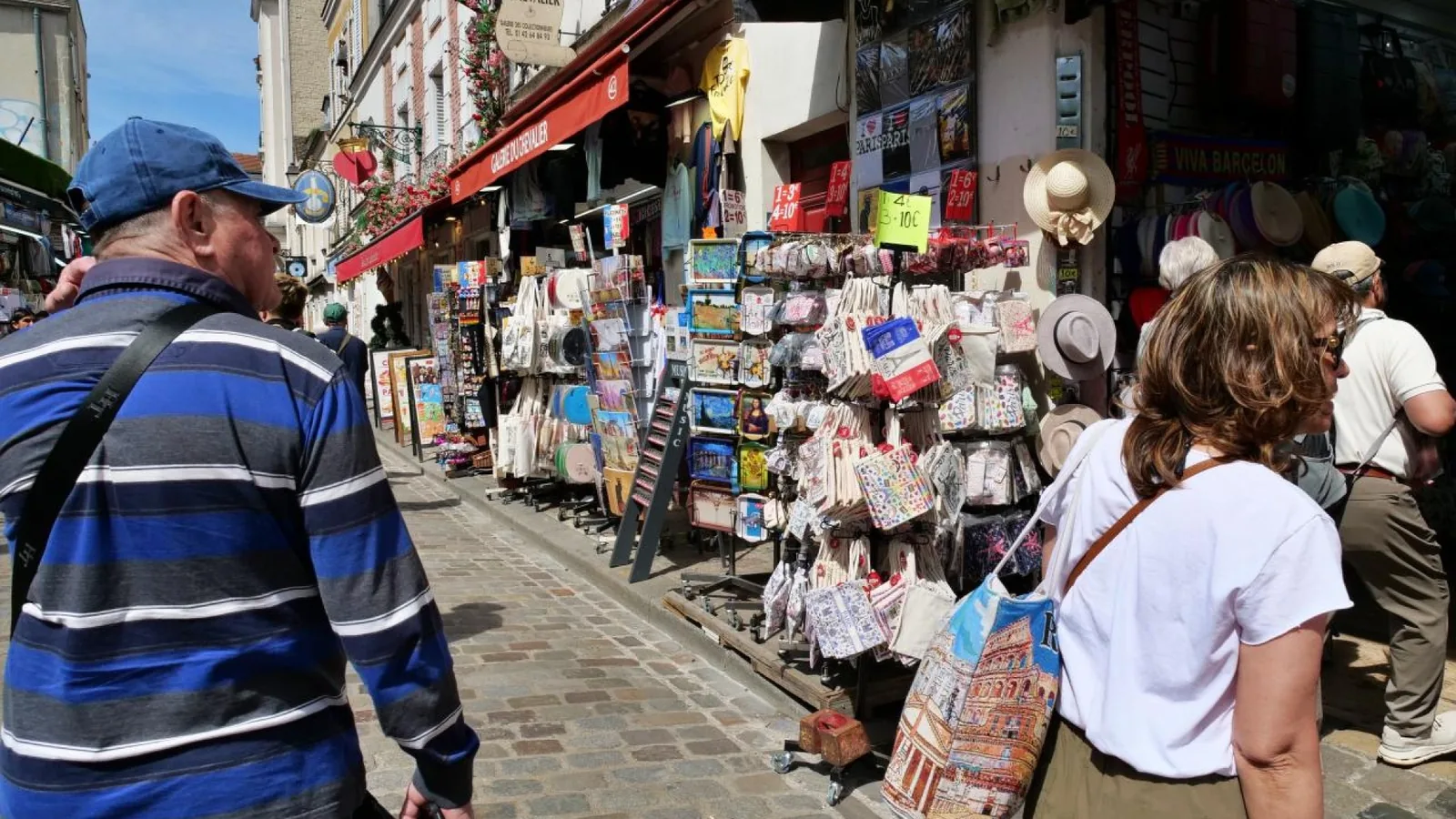 Tourists browsing souvenir shops on a narrow Montmartre street