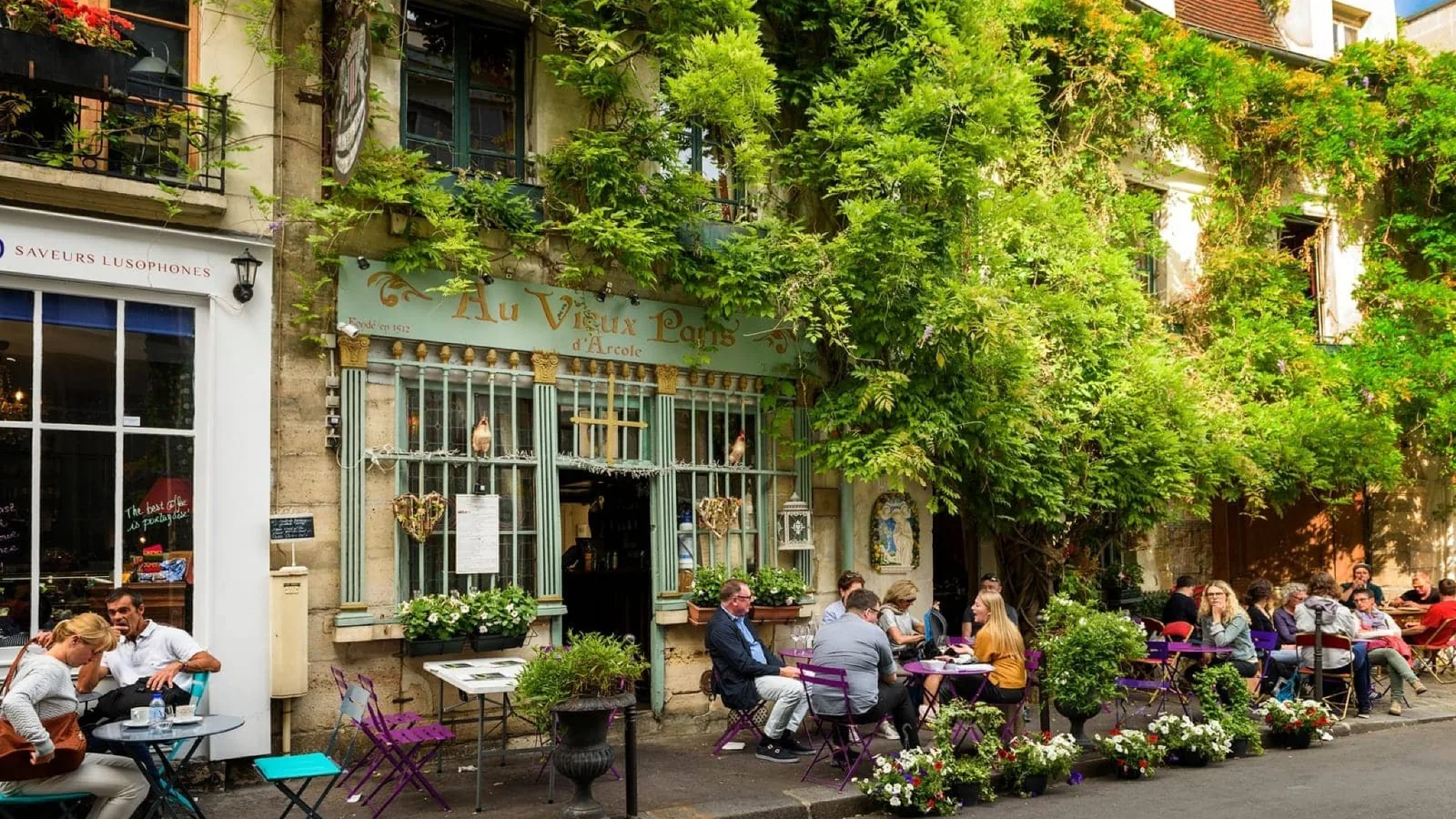 Leafy Paris café terrace with outdoor tables and people