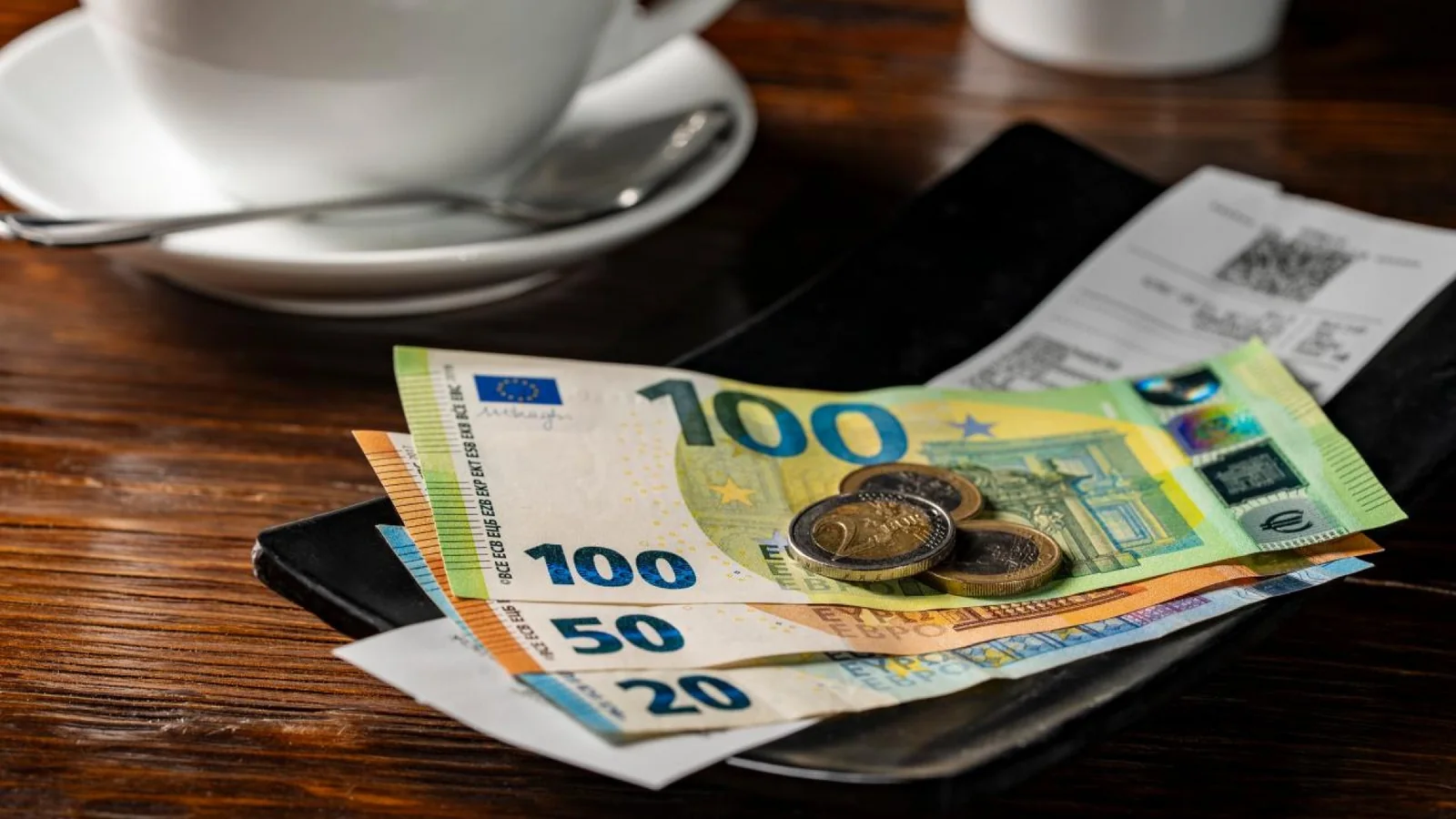 Euro banknotes and restaurant bill illustrating Michelin restaurant prices in Paris