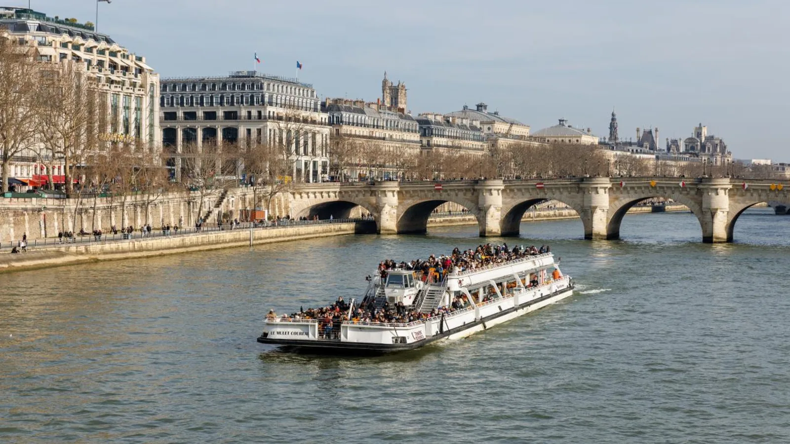 Crowded sightseeing boat cruising through central Paris