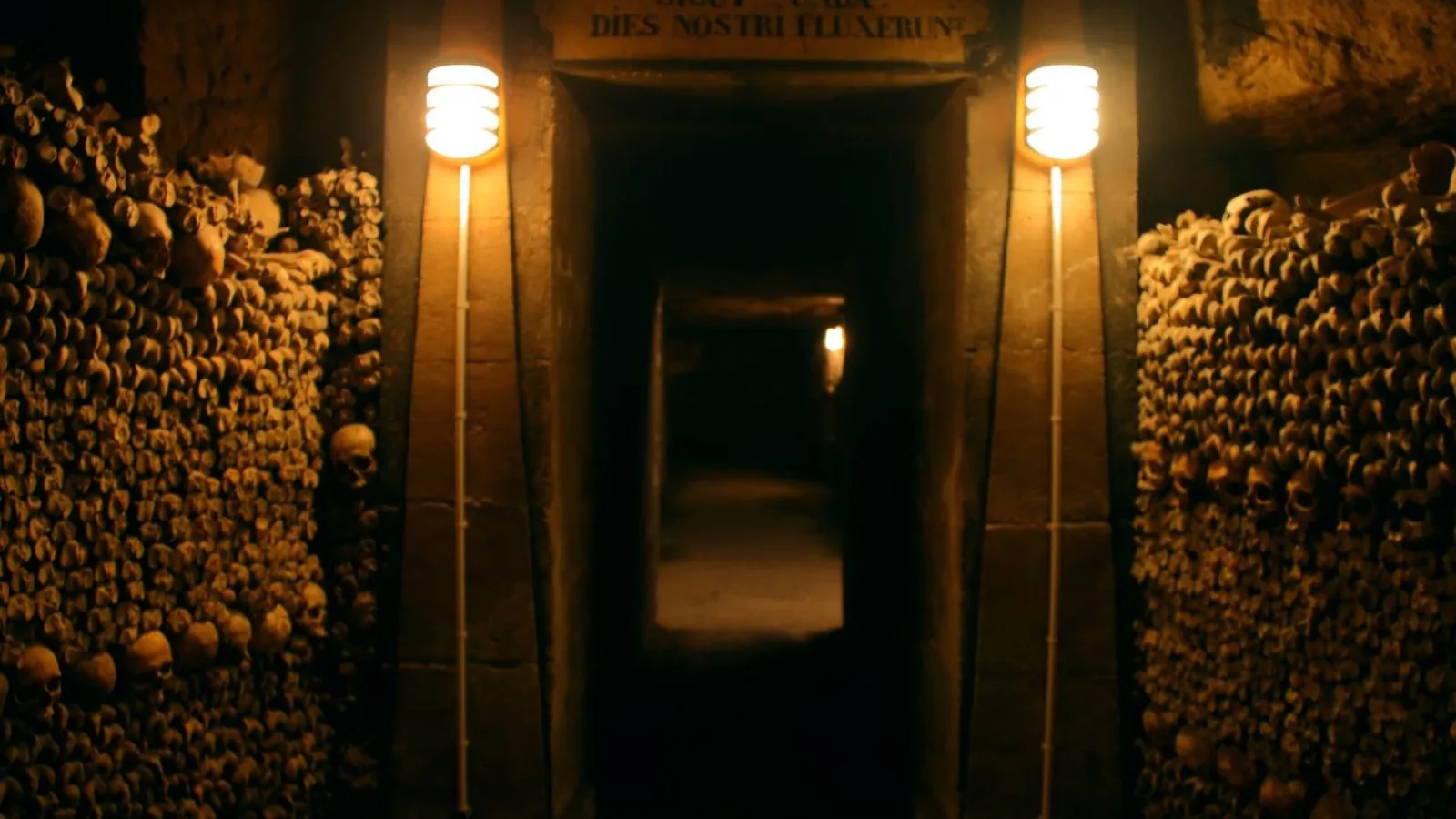 Paris Catacombs ossuary entrance surrounded by walls of bones and skulls