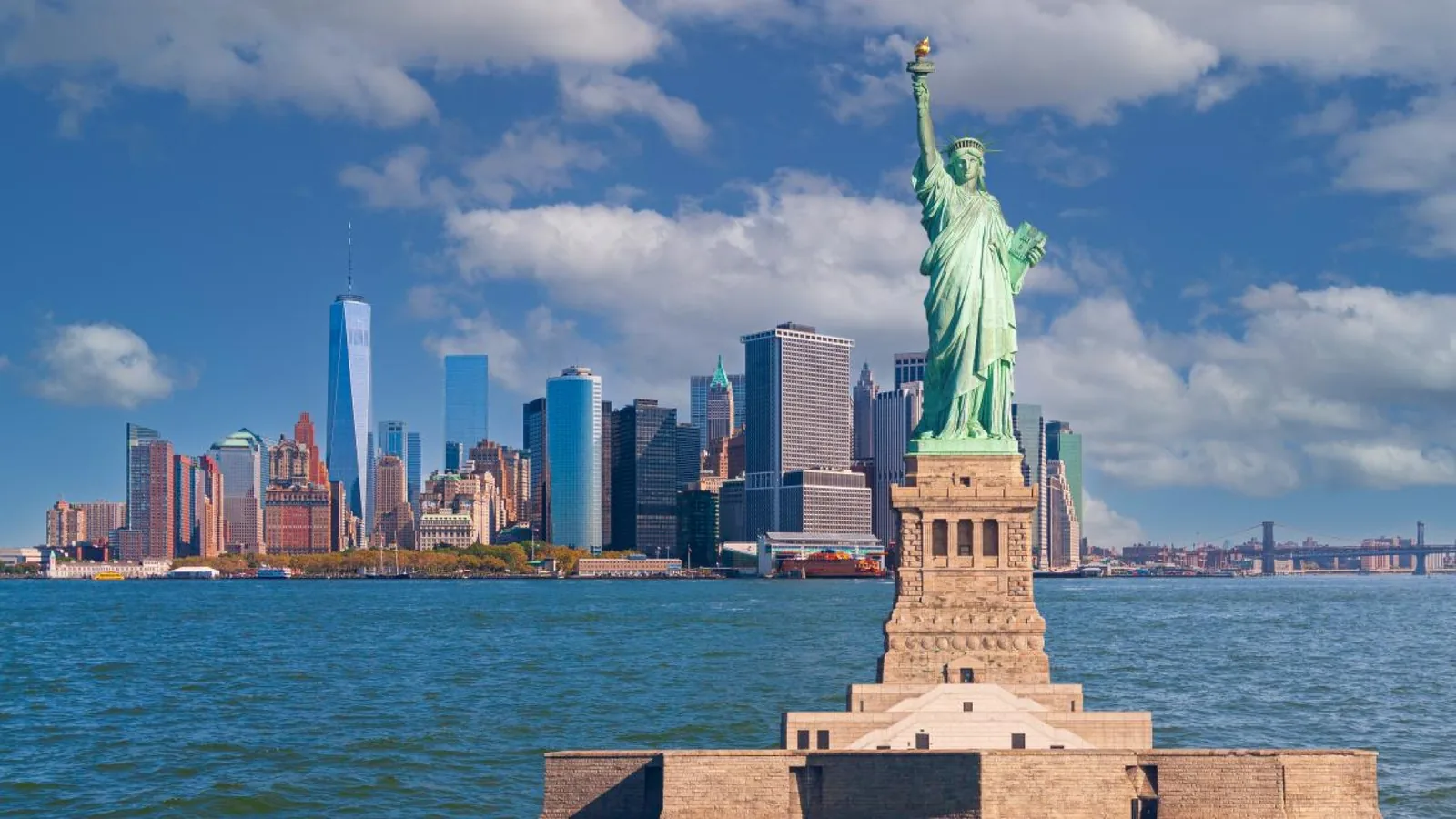 Statue of Liberty on Liberty Island with the Lower Manhattan skyline across New York Harbor